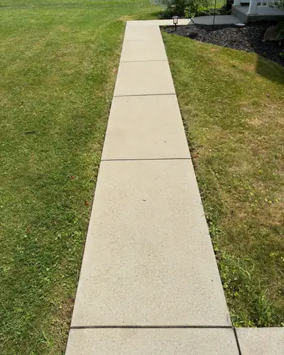 After: the same walkway, clean and pale, leading up to the porch